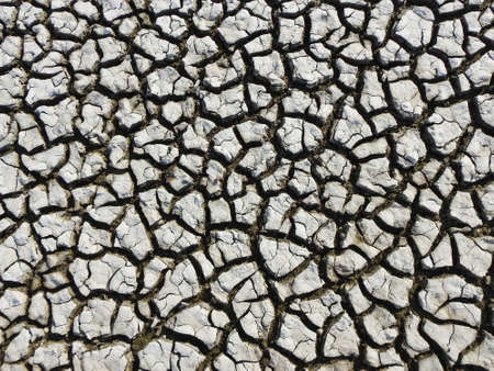 View of the dried-up bottom of a reservoir covered with cracks. Ecological catastrophy.の写真素材