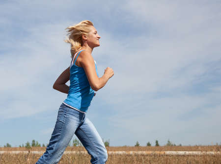 beautiful middle-aged woman jogging in natureの写真素材