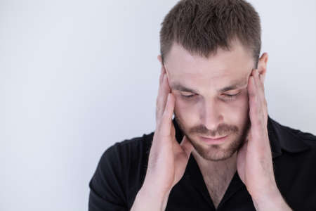 handsome young man in search of decision scratching his head