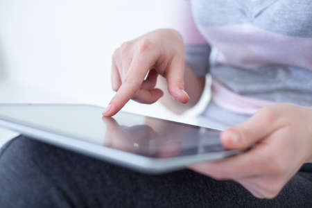 Close-up of female hands touching digital tablet