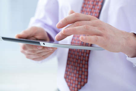 Close-up of male hands touching digital tabletの写真素材