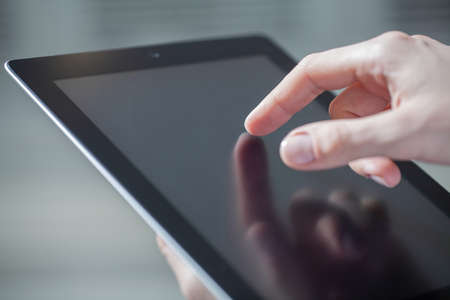 Close-up of male hands touching digital tabletの写真素材