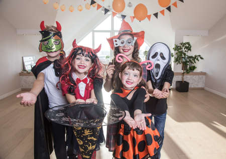 group of funny children in costume celebrate together a halloween partyの写真素材