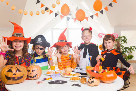 group of funny children in costume celebrate together a halloween partyの写真素材