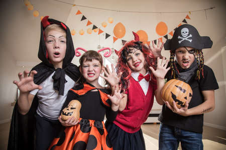group of funny children in costume celebrate together a halloween partyの写真素材