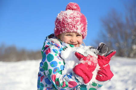 little girl playing on snow in winter timeの写真素材