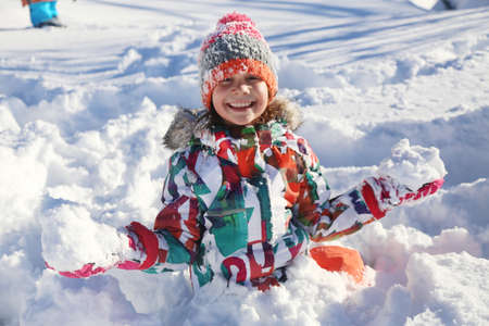 little girl playing on snow in winter timeの写真素材