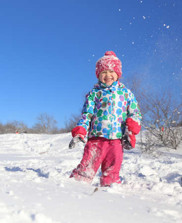 little girl playing on snow in winter timeの写真素材
