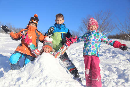 Group of children playing on snow in winter timeの写真素材