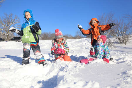 Group of children playing on snow in winter timeの写真素材