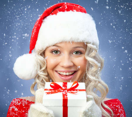 beautiful young blonde girl in santa claus hat smiles for christmas card.の写真素材