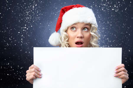 beautiful young blonde girl in santa claus hat smiles for christmas card.の写真素材