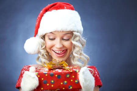 beautiful young blonde girl in santa claus hat smiles for christmas card.の写真素材