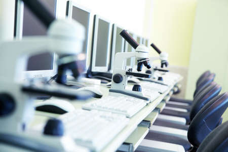 computer lab with monitors and educational microscopes on the tableの写真素材