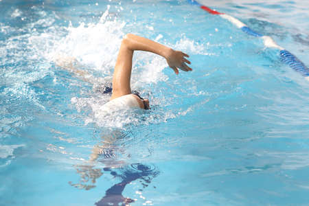 little girl swimming in the pool at the training in swimmingの写真素材