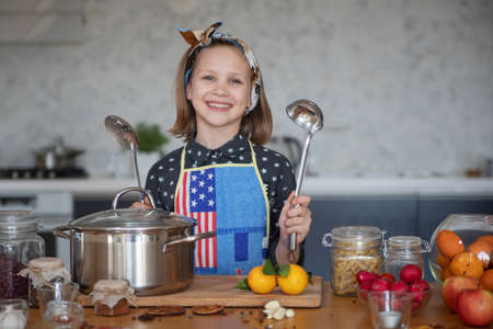 little girl cooking in the kitchen at homeの写真素材