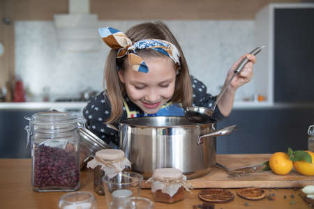 little girl cooking in the kitchen at homeの写真素材
