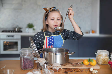 little girl cooking in the kitchen at homeの写真素材