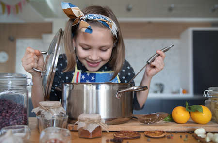 little girl cooking in the kitchen at homeの写真素材
