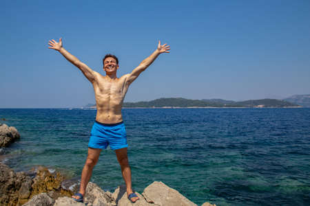 young man in swimwear enjoing on seacoast in sea resortの写真素材