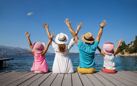 Family with two children sitting on the beach on sea coastの写真素材