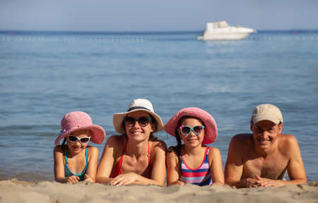 portrait of a happy family having a rest on the beach of a sea resortの写真素材