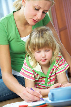 mom and daughter draw together at homeの写真素材