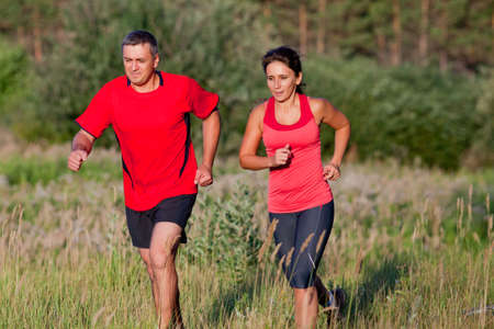 Pair of elderly people jogging on a summer dayの写真素材