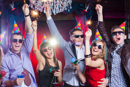 cheerful young company celebrates in a nightclubの写真素材