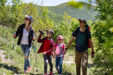 family with two kids have hiking through the mountainsの写真素材