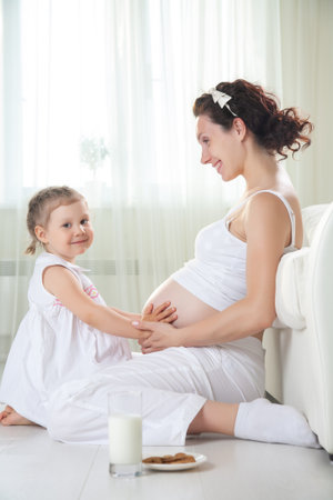 portrait of Little cute girl with her pregnant motherの写真素材