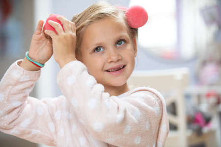 portrait of little cute ladies playing with doll in children's roomの写真素材