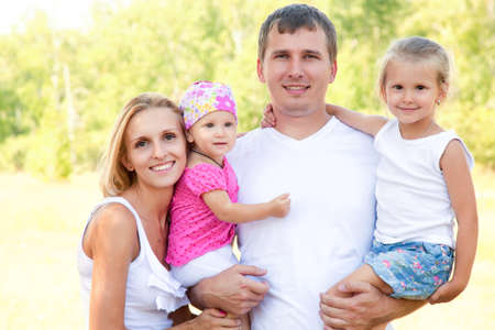 Portrait of young couple with their two little daughtersの写真素材