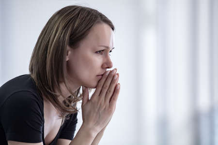 sad young woman sitting in crisis momentの写真素材