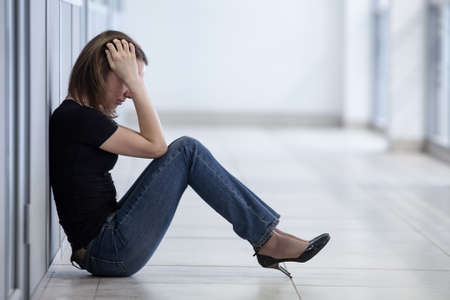 sad young woman sitting in crisis momentの写真素材