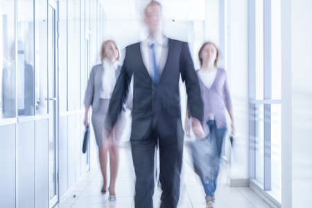 businesspeople walking in the corridor of an business center, pronounced motion blurの写真素材