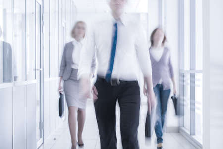 businesspeople walking in the corridor of an business center, pronounced motion blurの写真素材
