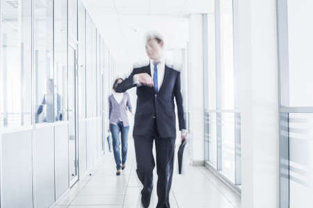 businesspeople walking in the corridor of an business center, pronounced motion blurの写真素材