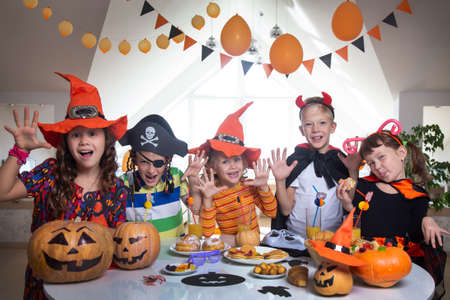 group of funny children in costume celebrate together a halloween partyの写真素材