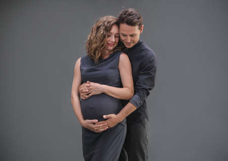 young man hugs his pregnant wife. The family is waiting for the birth of a baby.の写真素材