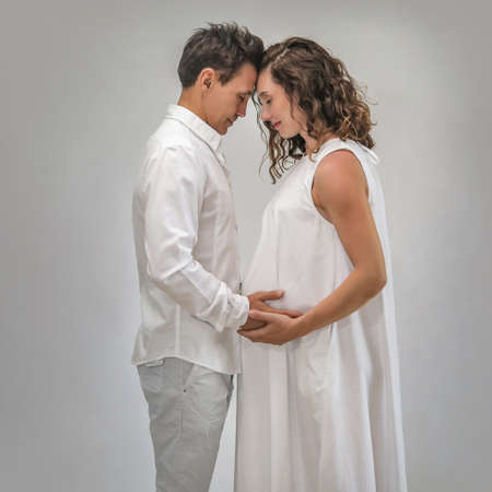 young man hugs his pregnant wife. The family is waiting for the birth of a baby.の写真素材