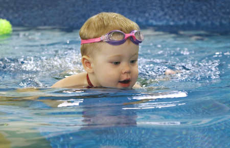 Baby boy swims in the pool with pleasureの写真素材