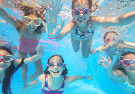 little happy kids swimming in pool underwater.の写真素材