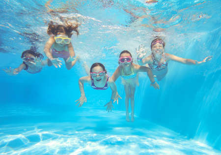 little happy kids swimming in pool underwater.の写真素材