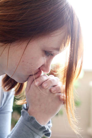 Teen girl with red hair and acne on the skin is cryingの写真素材
