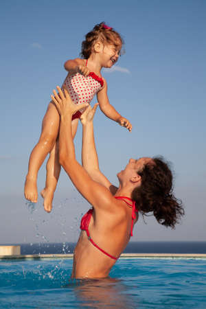 Young slim mother with young daughter out of the sea in the resortの写真素材
