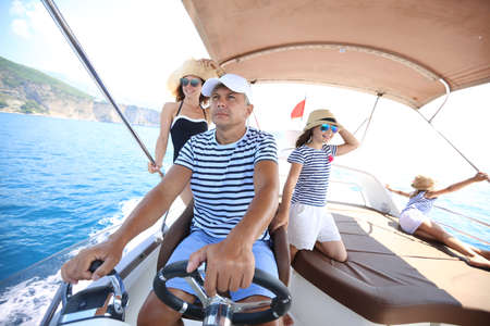 Family with little girl enjoying a holiday on yacht in the seaの写真素材