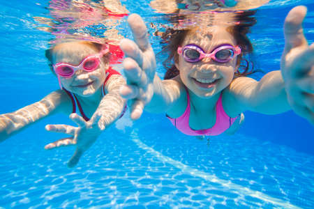 little girls swimming in pool underwater.の写真素材