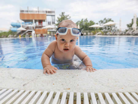 Baby boy swimming in the pool with pleasure