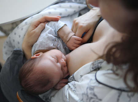 young mother breastfeeding newborn babyの写真素材